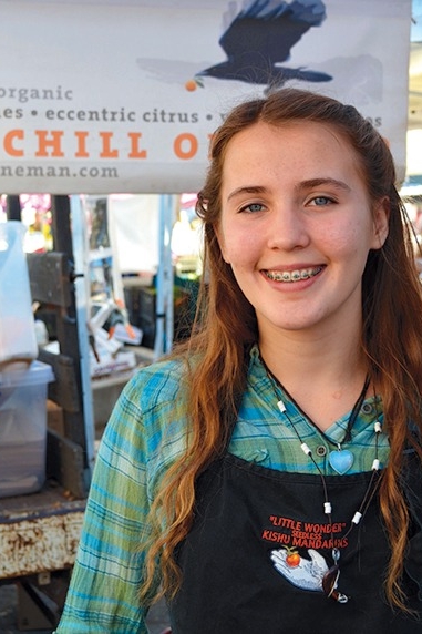 A Churchill Orchard worker greets shoppers with a smile and many varieties of citrus and avocados.